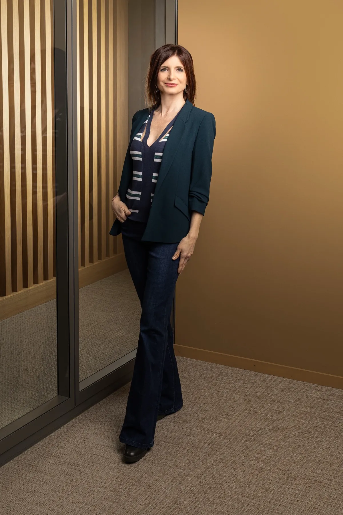 Véronique Pagano, portrait en buste, dans un intérieur aux lignes architecturales de bois et de métal.